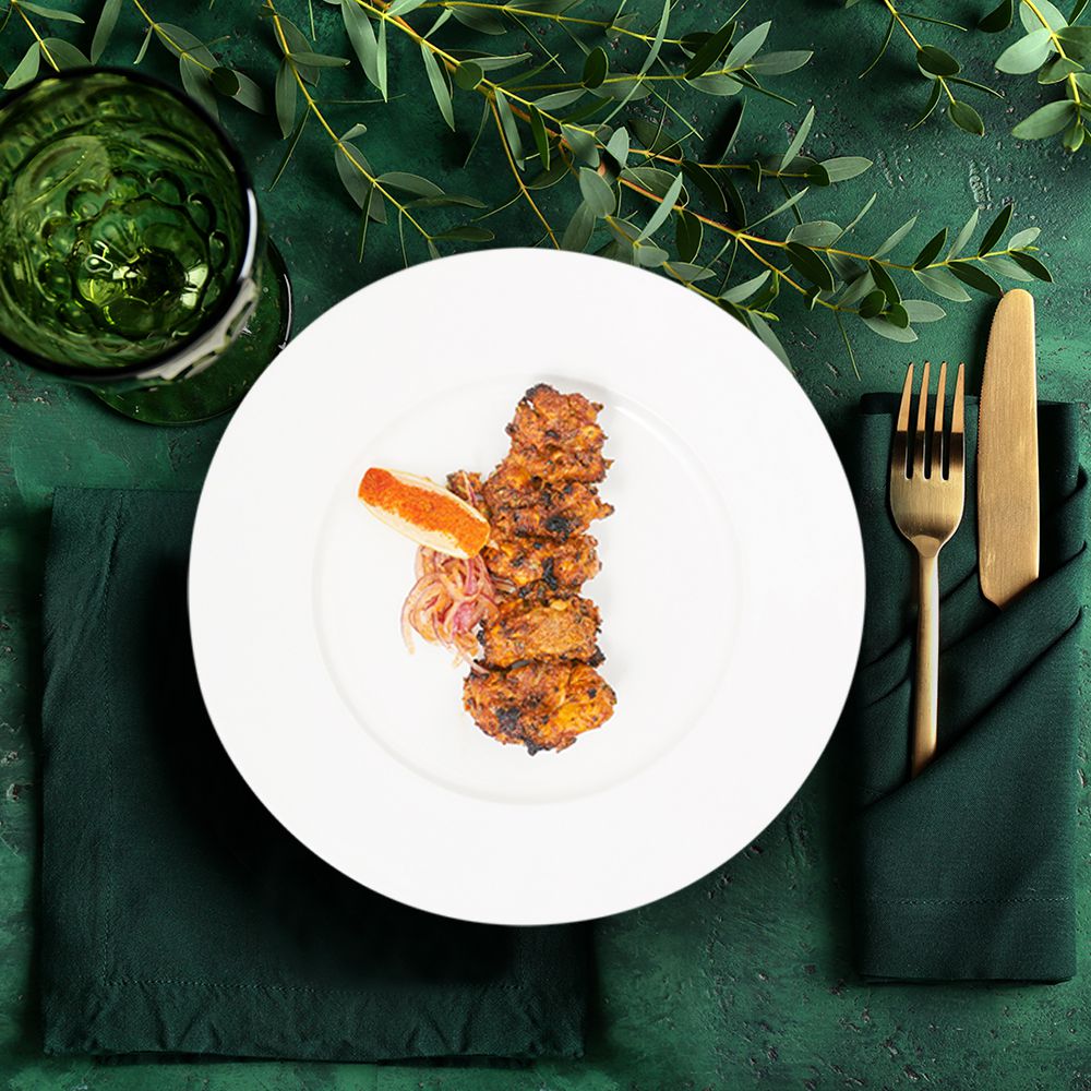 behdgi murgh curry dish from above on a forest green tablecloth