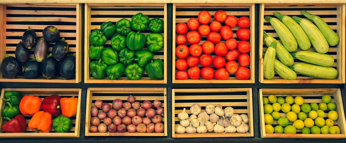 vegetables in wooden boxes at a market organised by type