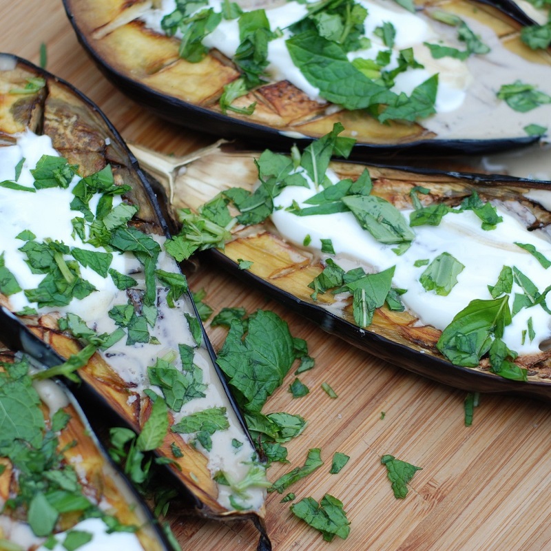 stuffed aubergines on a wooden chopping board