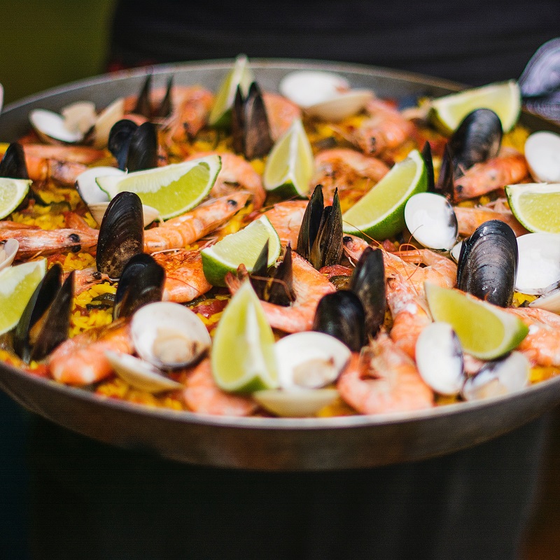 spanish national dishes paella with lime and mussels in a black dish