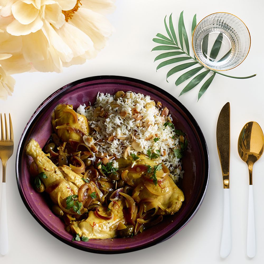 moroccan chicken tagine from above on a white table with flowers