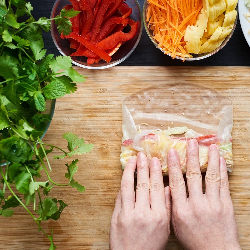 hands creating a vegan spring roll