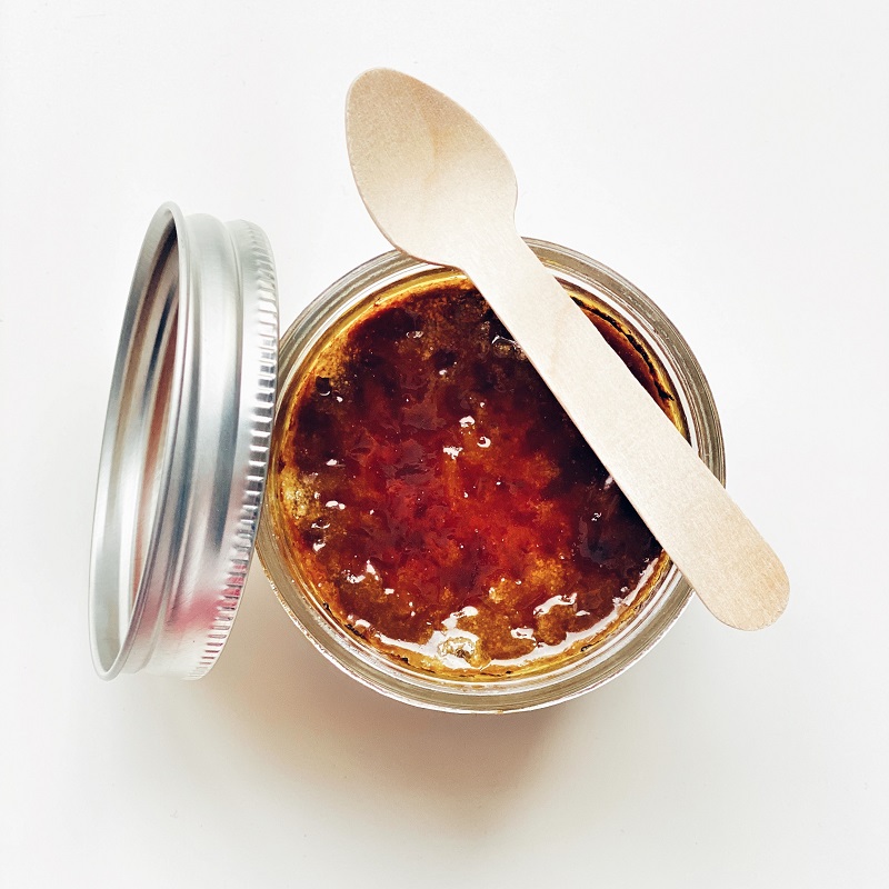 jar of chutney taken from above with a wooden spoon
