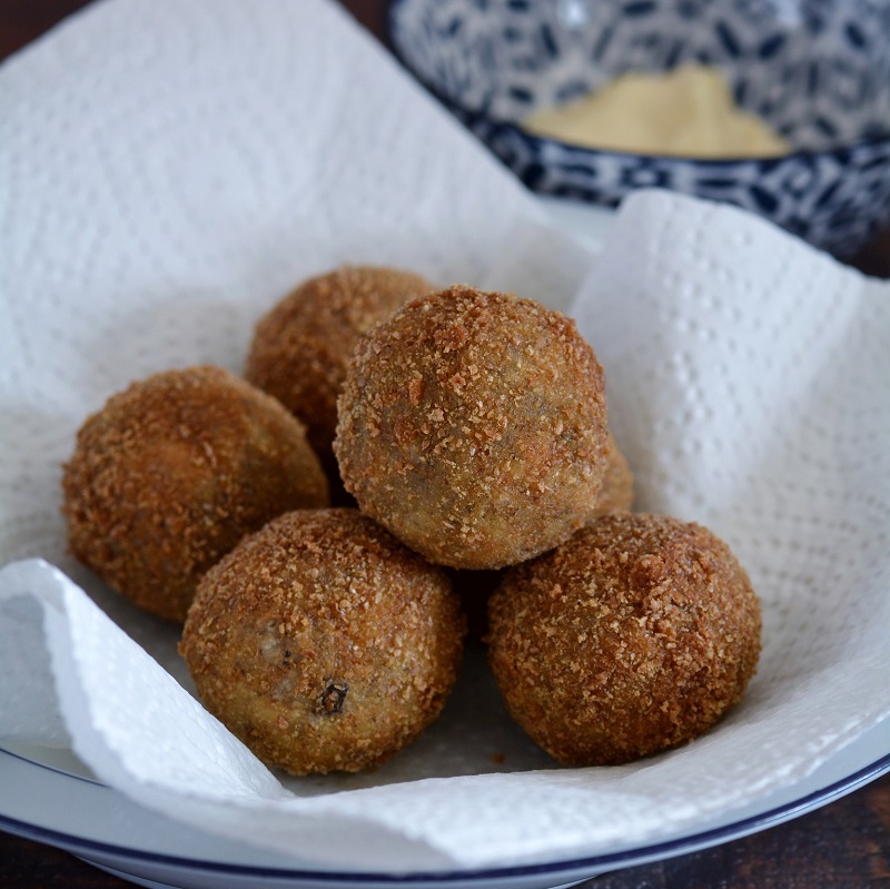 traditional sicilian recipes arancini balls in a blue and white bowl