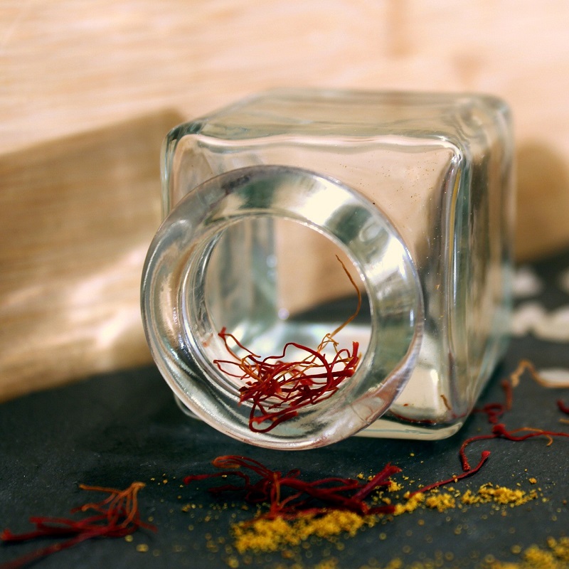 jar of saffron turned onto its side on a charcoal slab