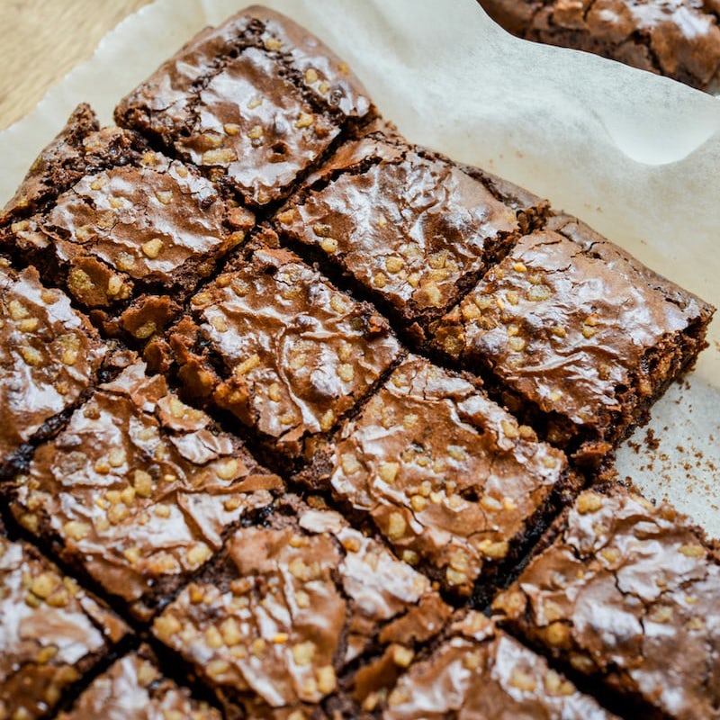 Batch of brownies cut into squares on parchment paper