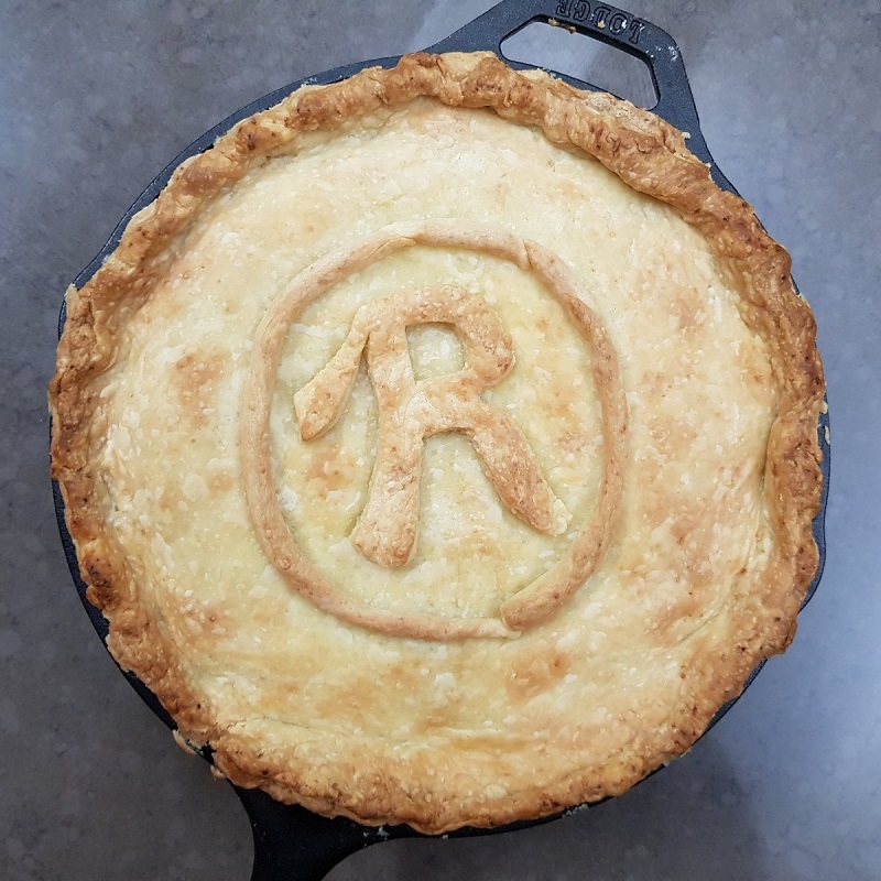 chicken pie seen from above with an r symbol in the pastry