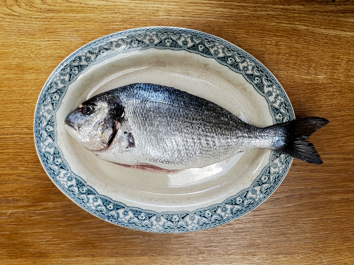 sea bream on an ornate plate on top of a wooden table