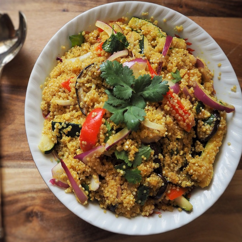 Bowl of chicken quinoa salad with vegetables and fresh herbs