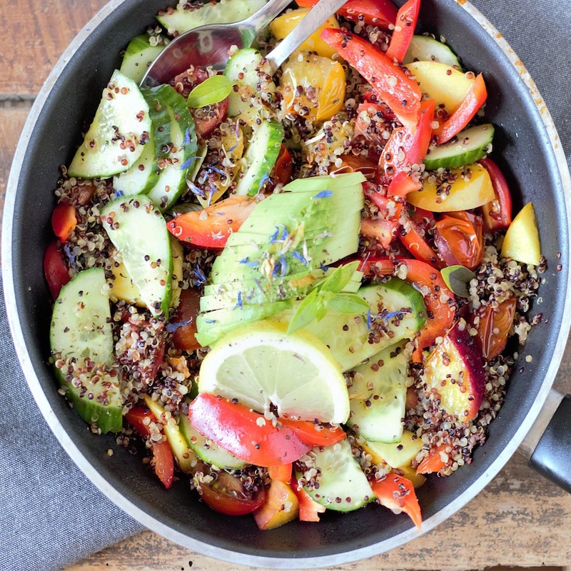 bowl of quinoa salad with peppers, lemon and avocado