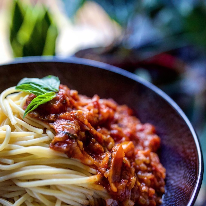 bowl of spaghetti with vegan bolognese and basil