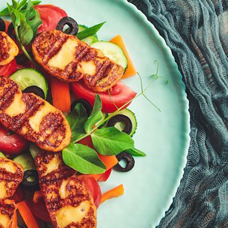 salad with grilled halloumi on a blue plate