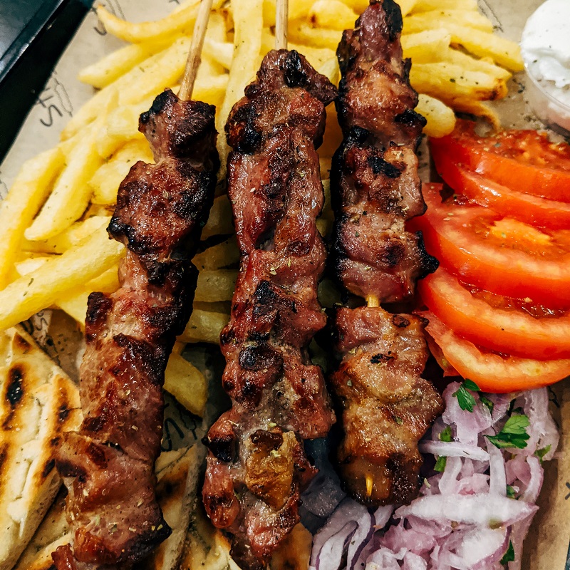 traditional greek souvlaki with chips and tomatoes