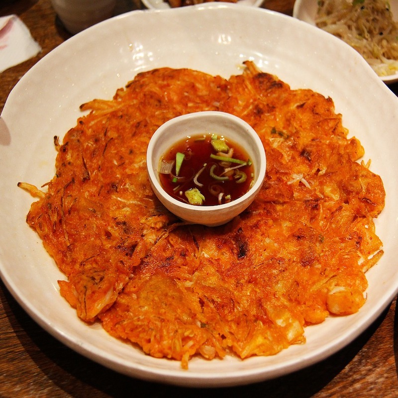 korean pancake on a plate with a dipping sauce in the middle