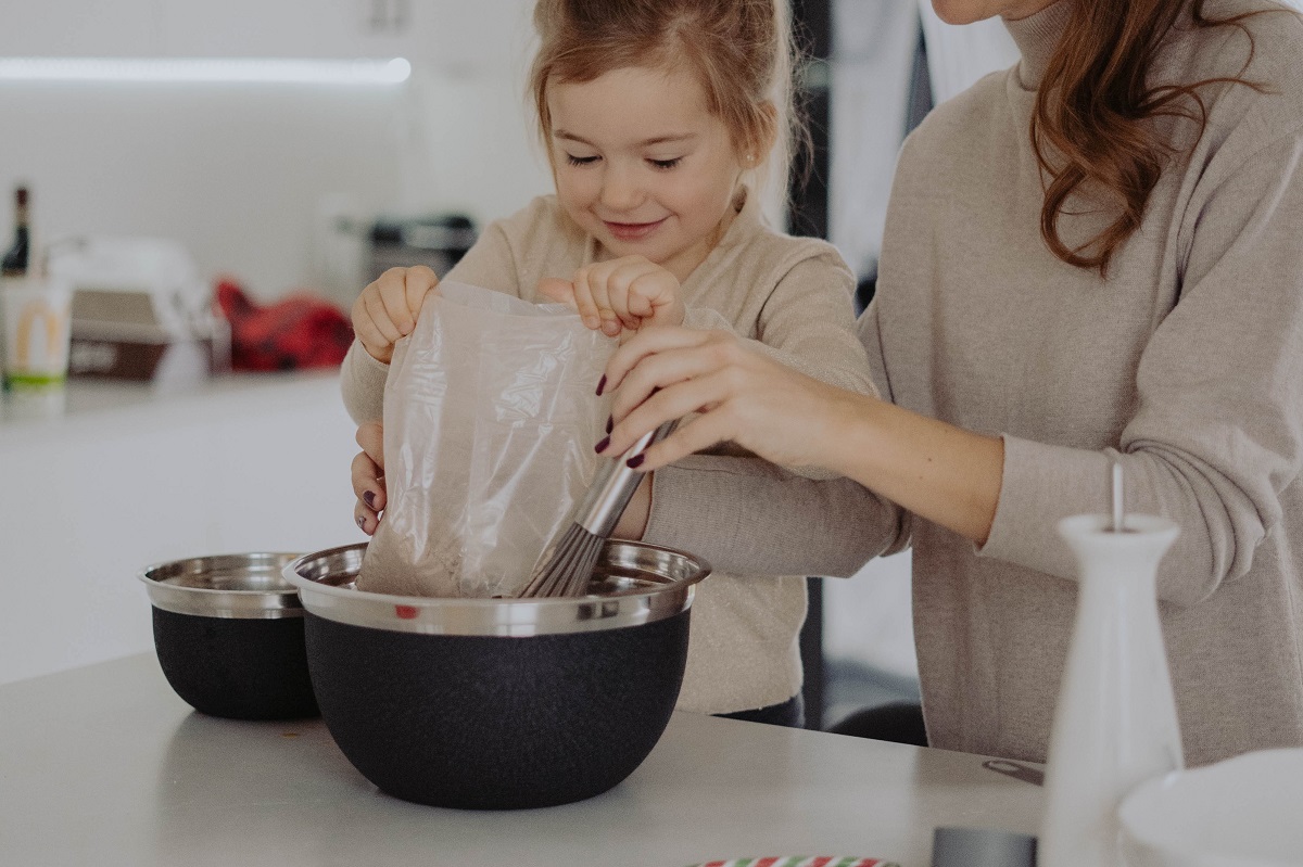 little girl baking in the kitchen with her mum