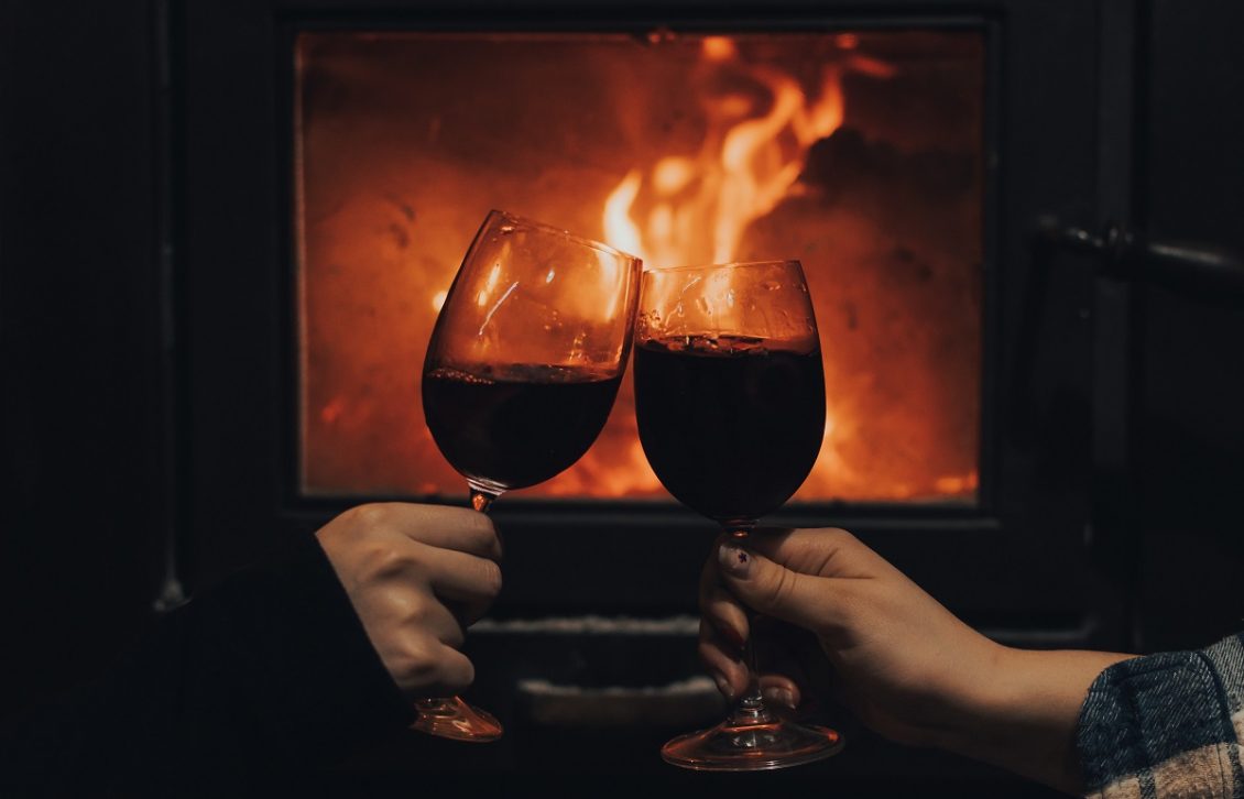 autumn wine glasses clinking by the fire