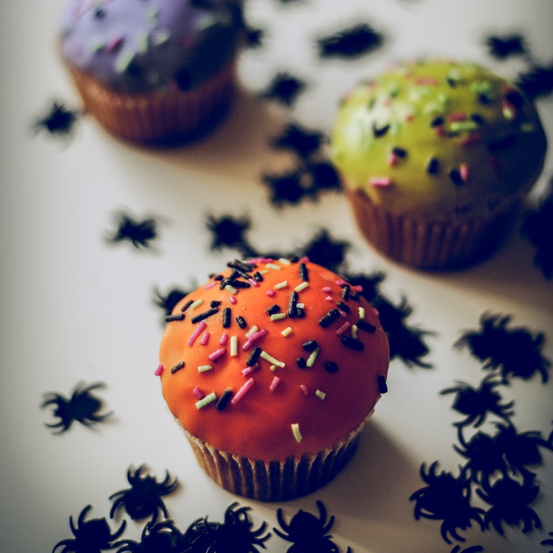 scary halloween cupcakes orange green and purple with spiders around them
