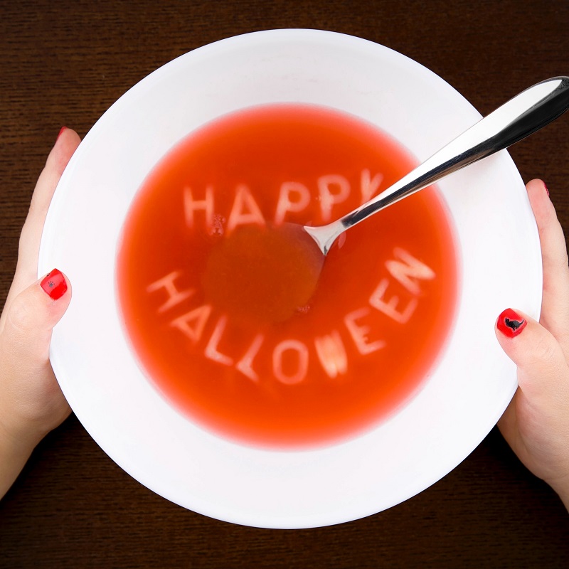 halloween recipe ideas pumpkin soup with letters in a white bowl