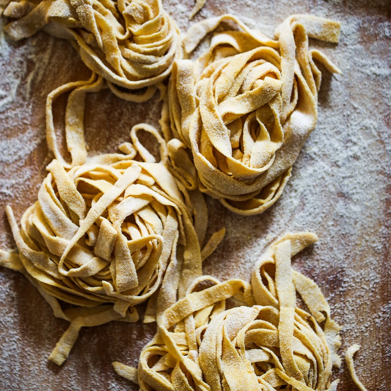 nests of fresh italian tagliatelle pasta on a slate board