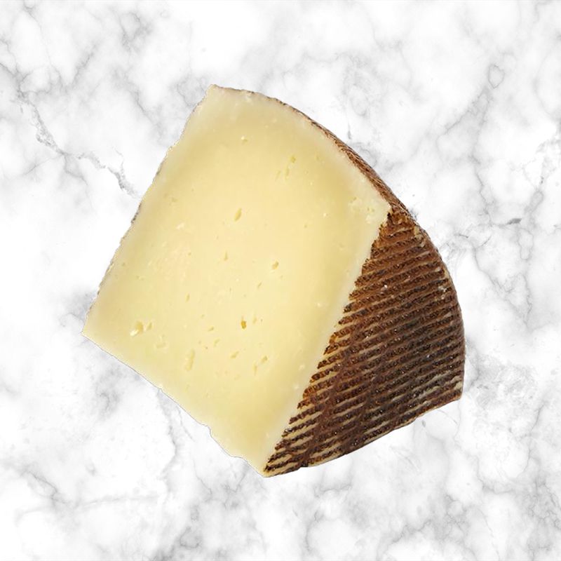 spanish manchego cheese on a white marble background