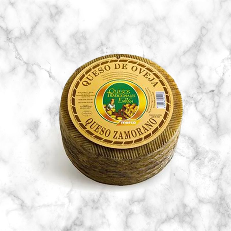 spanish zamorano cheese in yellow packaging on a white marble background
